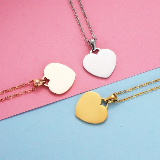 Collares de corazón dorado, plateado y rosado sobre fondo rosa y azul, ¡ideales para regalo!